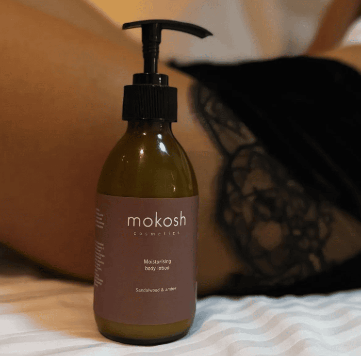 Lubrifikues i trupit MOKOSH me aromë Sandalwood dhe Amber për hidratim dhe ndriçim të lëkurës.