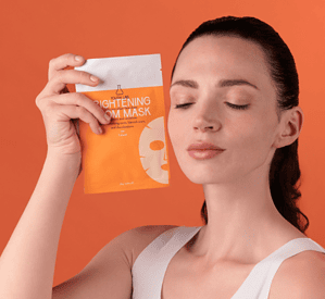 Vajzë me maskë për ndriçim të lëkurës, produkt kozmetik për fytyrën.